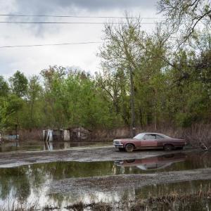 Old Red Car in Flooded Yard, Braithwaite, Louisiana by Carolyn Monastra